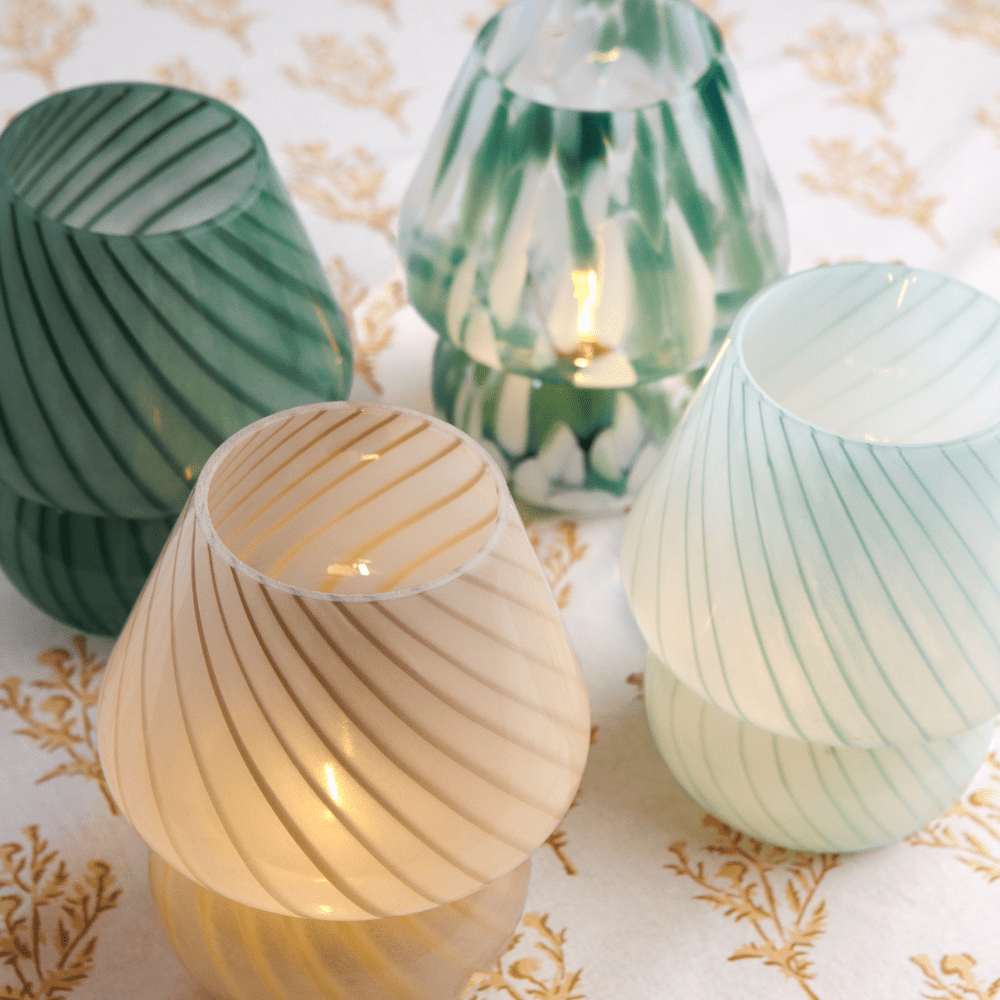 Four lamps with a conical shape on a patterned tablecloth