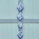 Blue and white patterned napkins hanging on a blue wooden door.