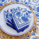 Folded blue and white patterned napkins on a plate.