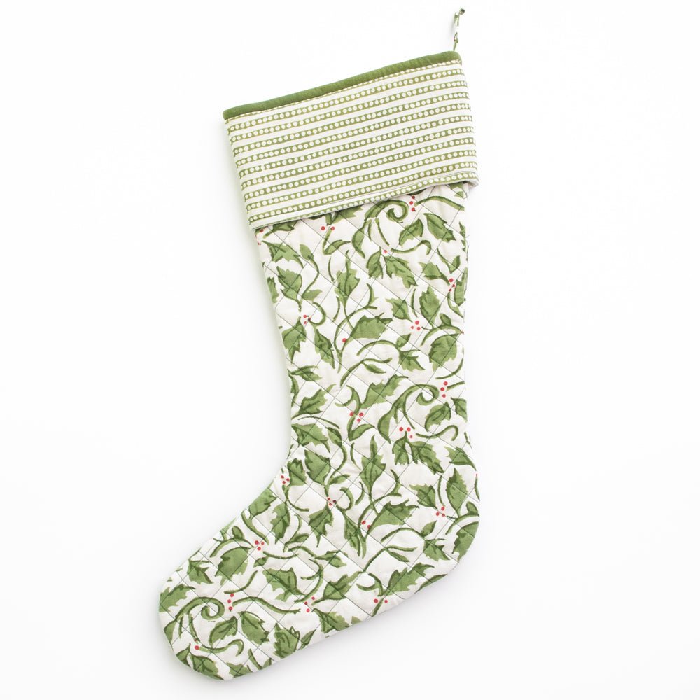 Quilted stocking with a holly print on a white background