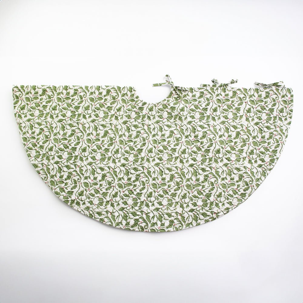 A quilted tree skirt with a festive Holly Berry design in shades of green and red.