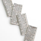 A set of folded cloth napkins with a geometric pattern, displayed on a white background