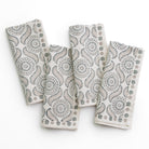 A set of folded cloth napkins with a geometric pattern, displayed on a white background