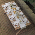 A hunter green table runner with a palm tree pattern displayed on a table set for dining.
