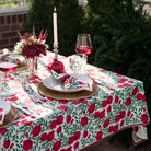 A table setting featuring pomegranate napkins and a tablecloth.