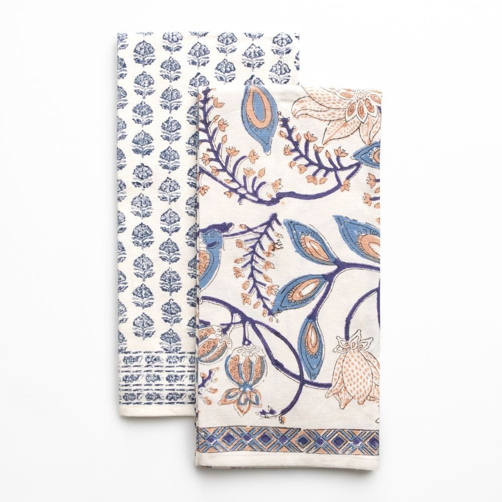 Two patterned tea towels with blue and orange designs on a white background