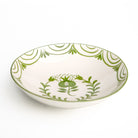 White ceramic bowl with green floral patterns on a white background