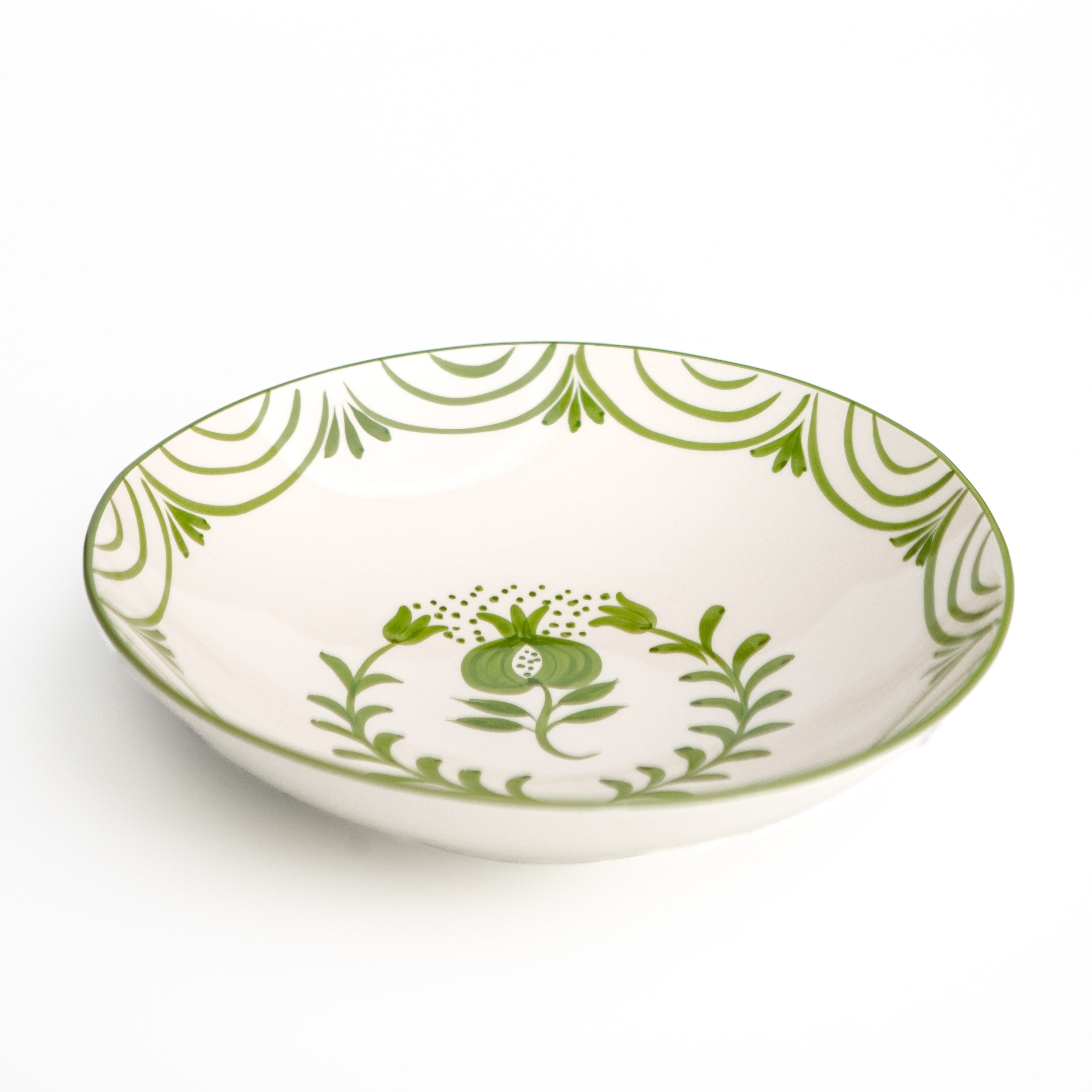 White ceramic bowl with green floral patterns on a white background