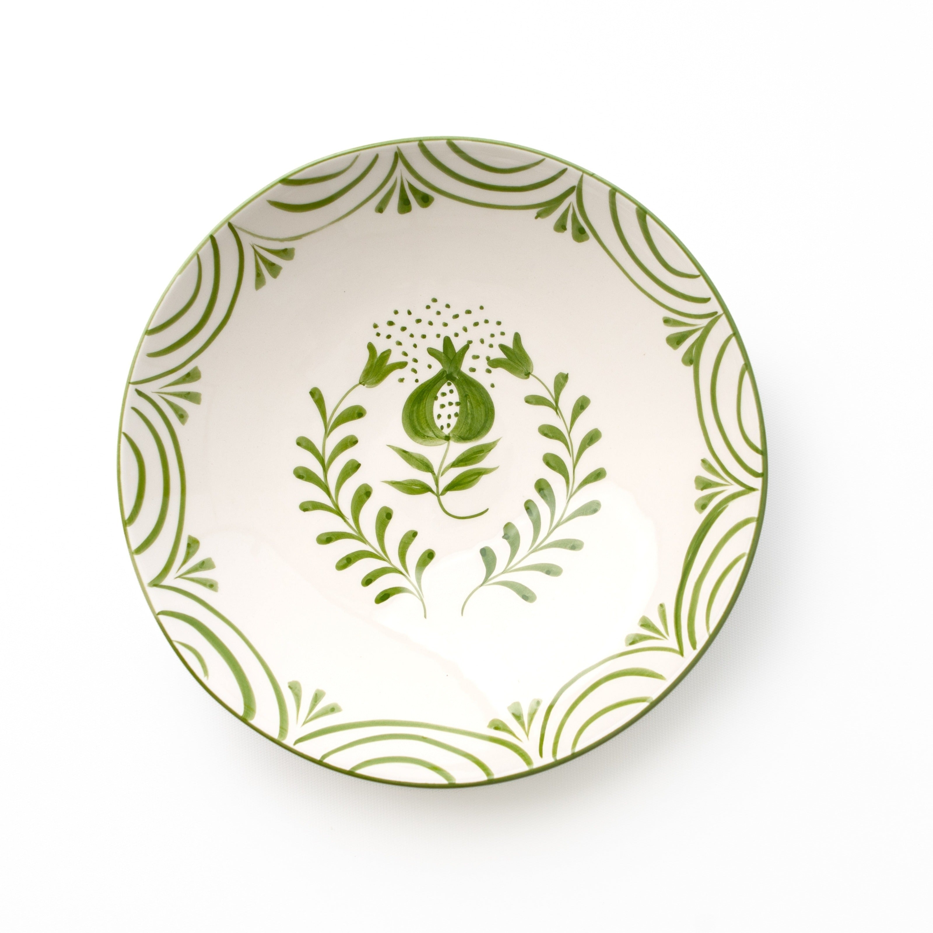 Decorative ceramic bowl with green floral design on a white background