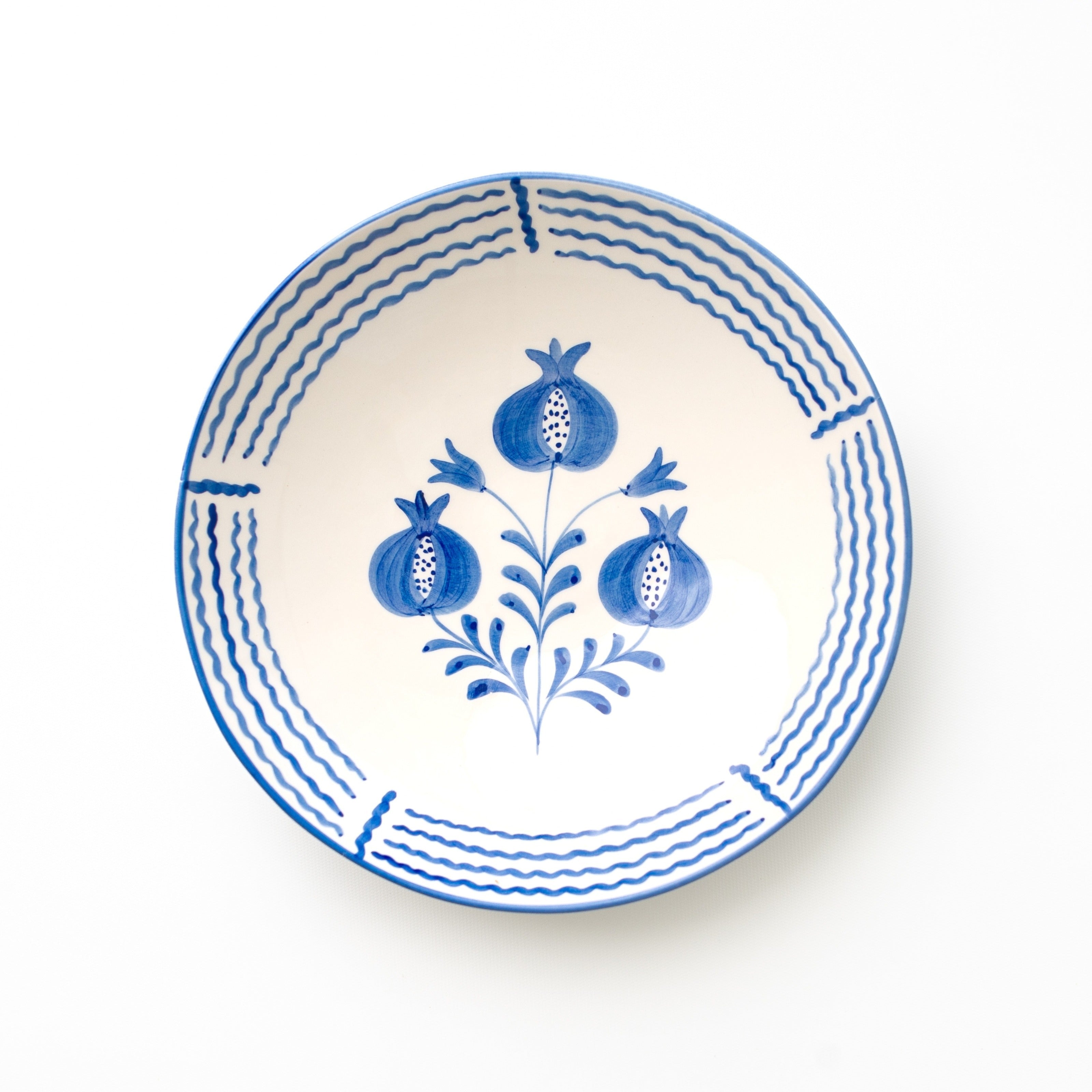 Ceramic serving bowl with blue floral and pomegranate design on a white background