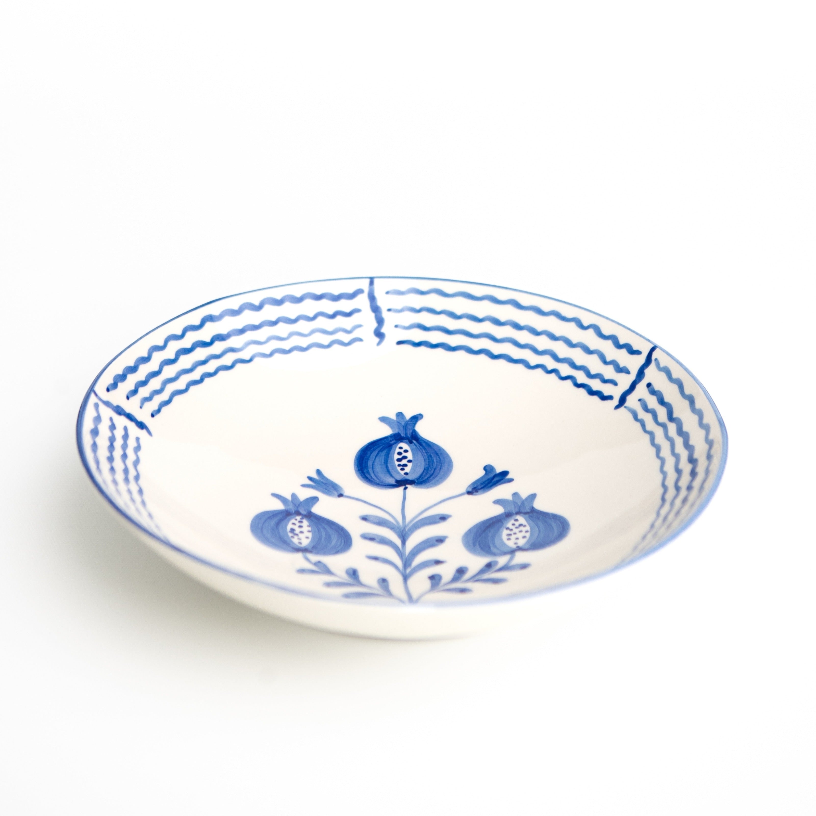 White ceramic serving bowl with blue floral patterns on a white background