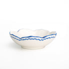 White ceramic bowl with cobalt blue decorative rim on a white background