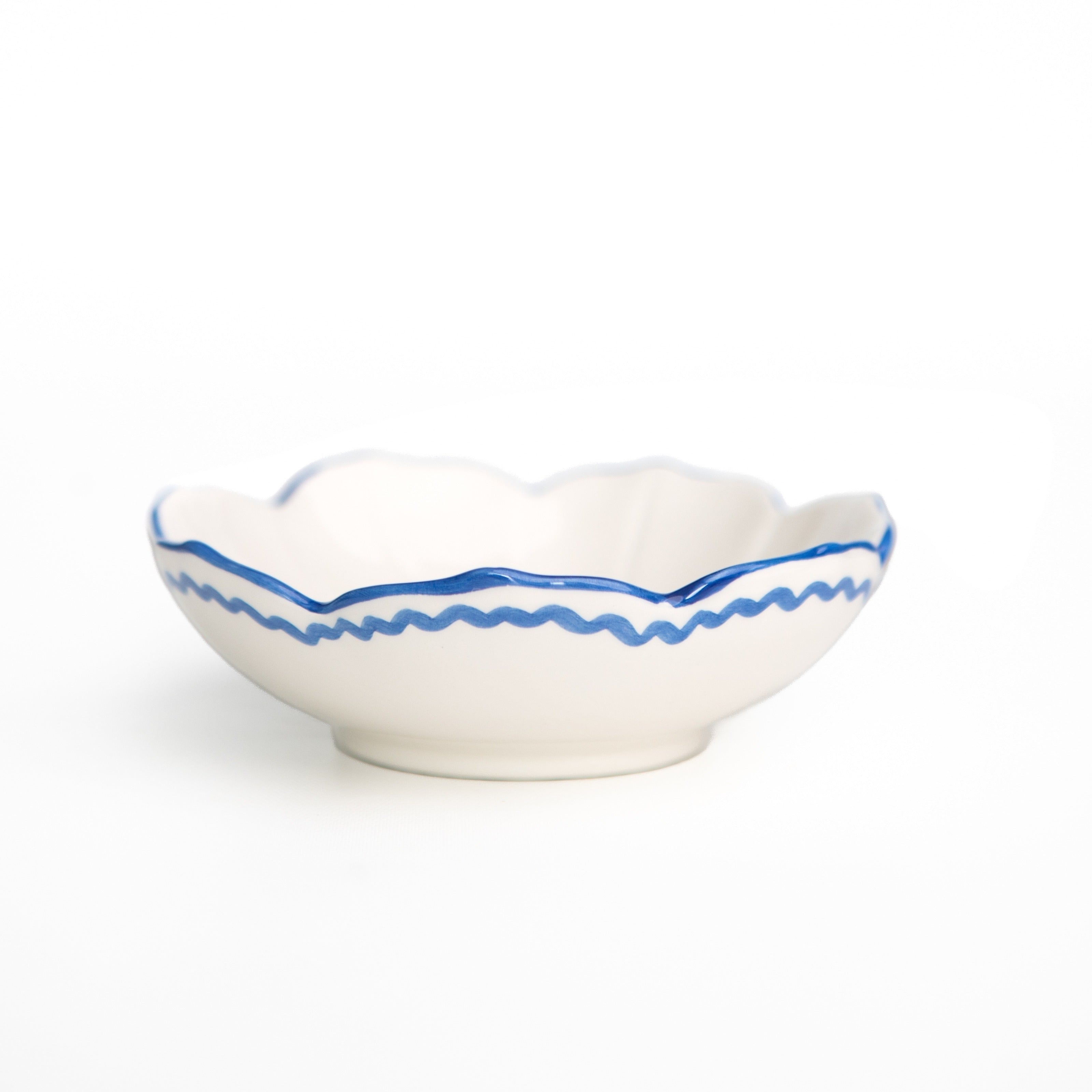 White ceramic bowl with cobalt blue decorative rim on a white background