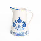 White ceramic pitcher with cobalt blue floral patterns on a white background