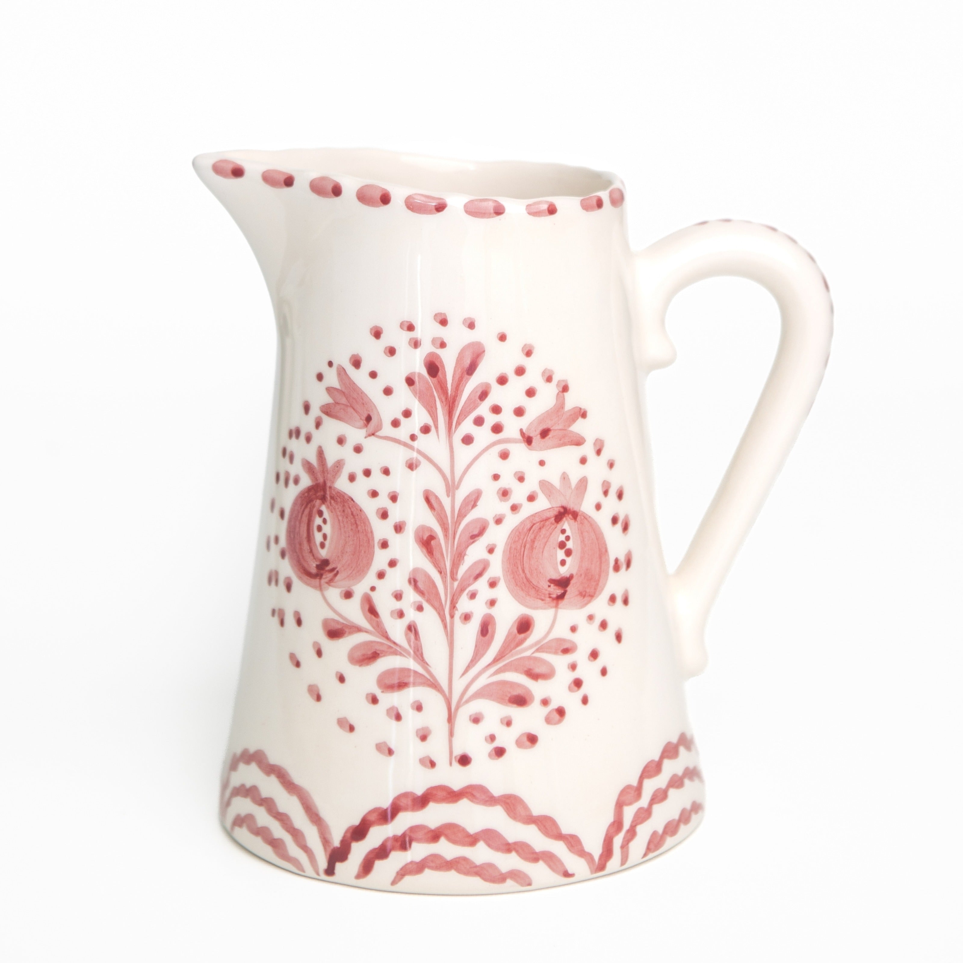 White ceramic pitcher with rose floral patterns on a white background
