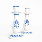 White candle holders with cobalt blue floral designs on a white background
