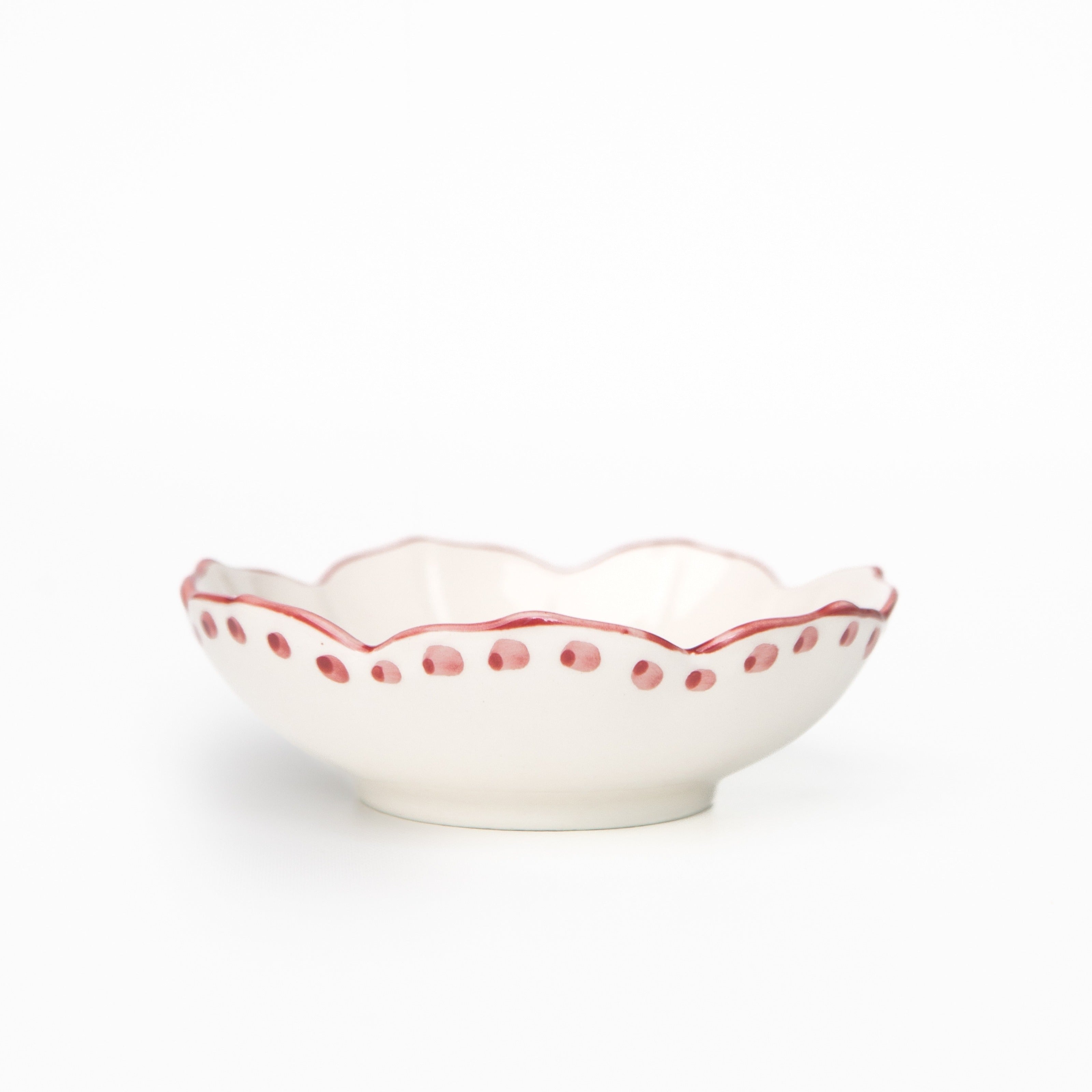 White ceramic bowl with red decorative rim on a white background
