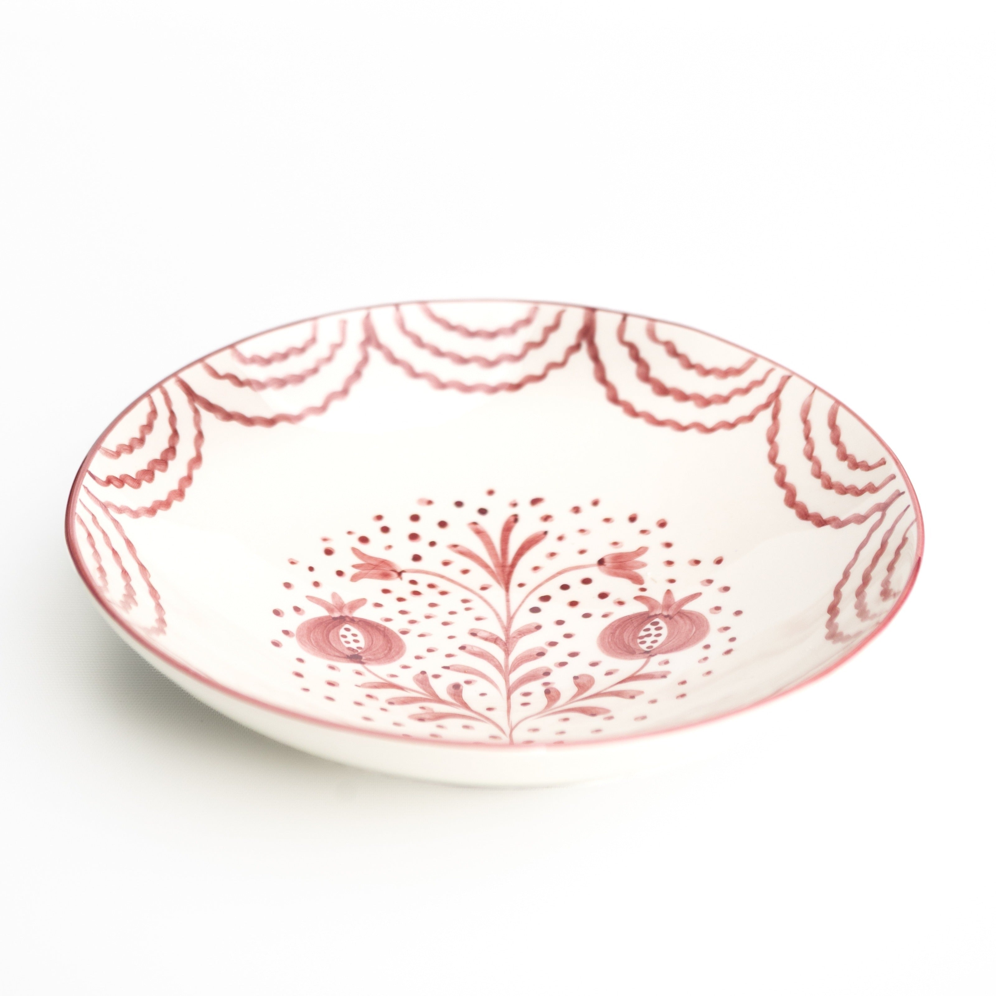 Decorative ceramic plate with pink floral pattern on a white background