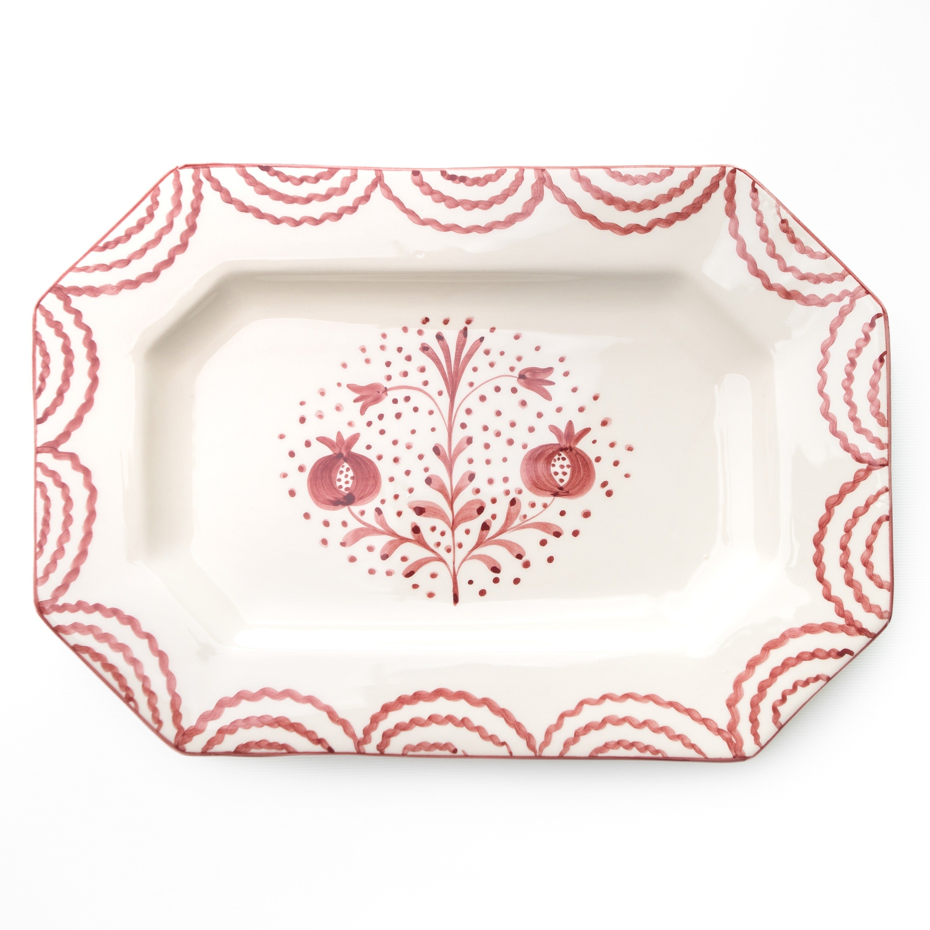 Decorative platter with red floral and pomegranate design on a white background
