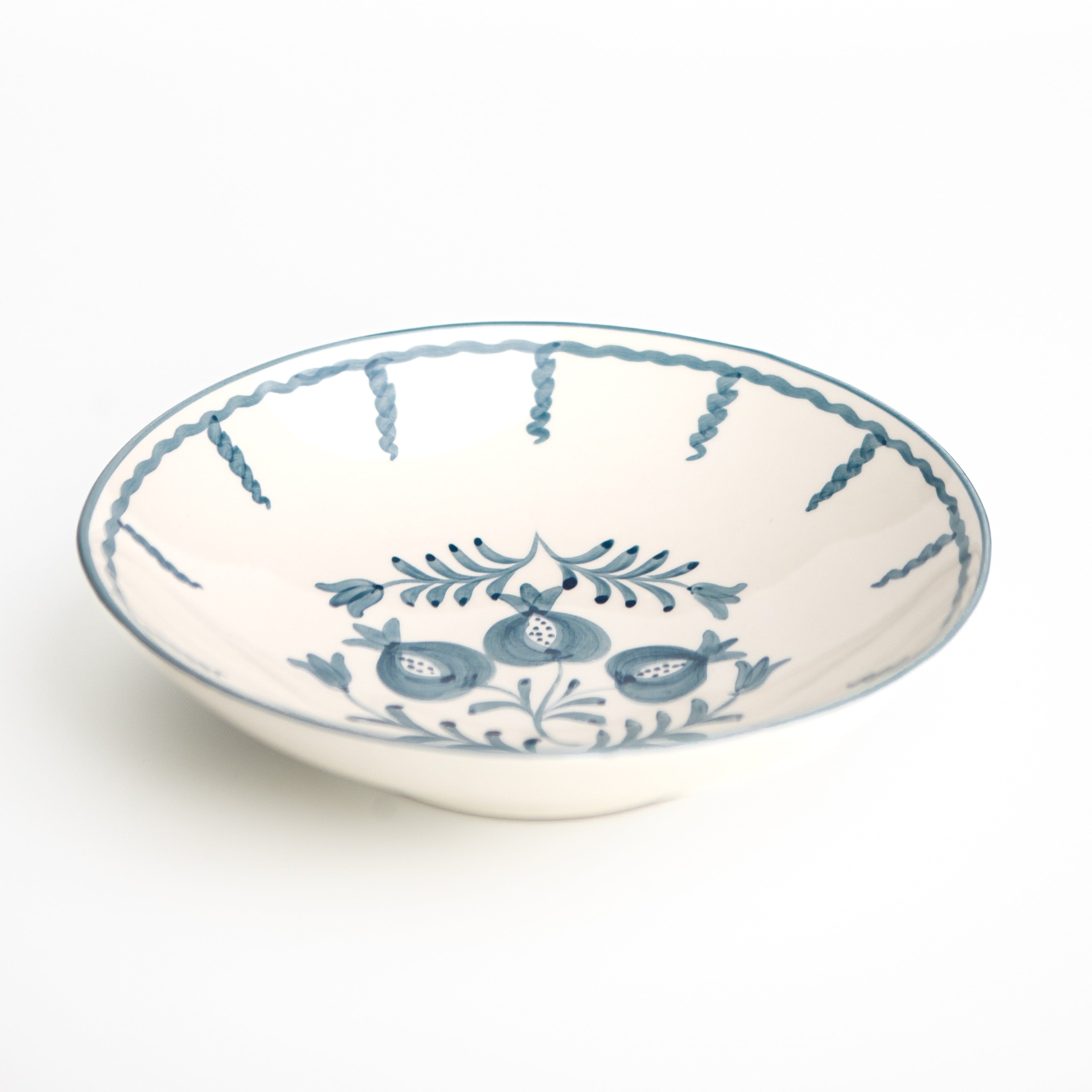 Ceramic serving bowl with blue floral design on a white background