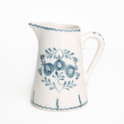 White ceramic pitcher with blue floral patterns on a white background