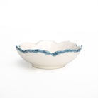 White ceramic bowl with blue rim on a white background