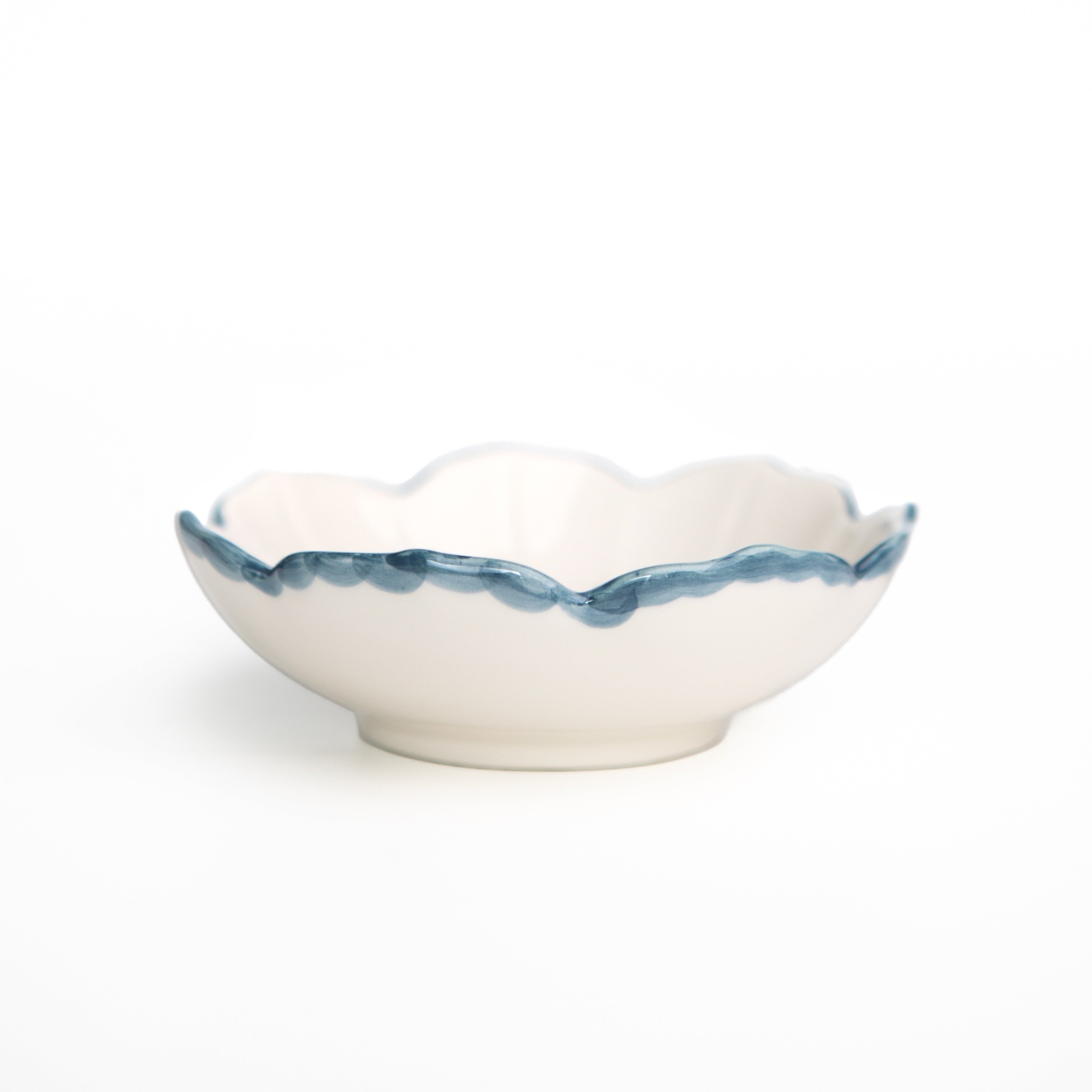 White ceramic bowl with blue rim on a white background
