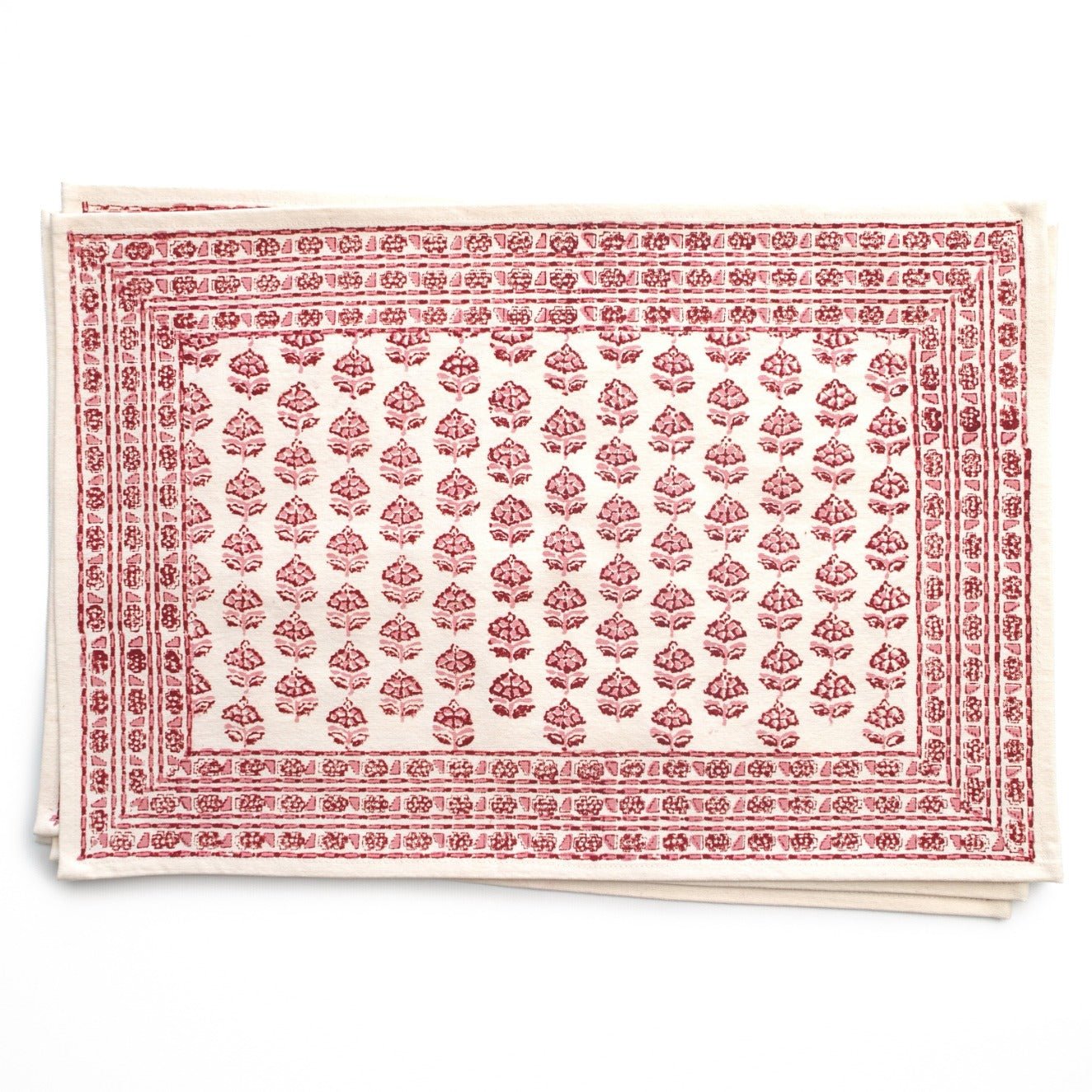 Stack of red and white patterned tablecloths on a white background