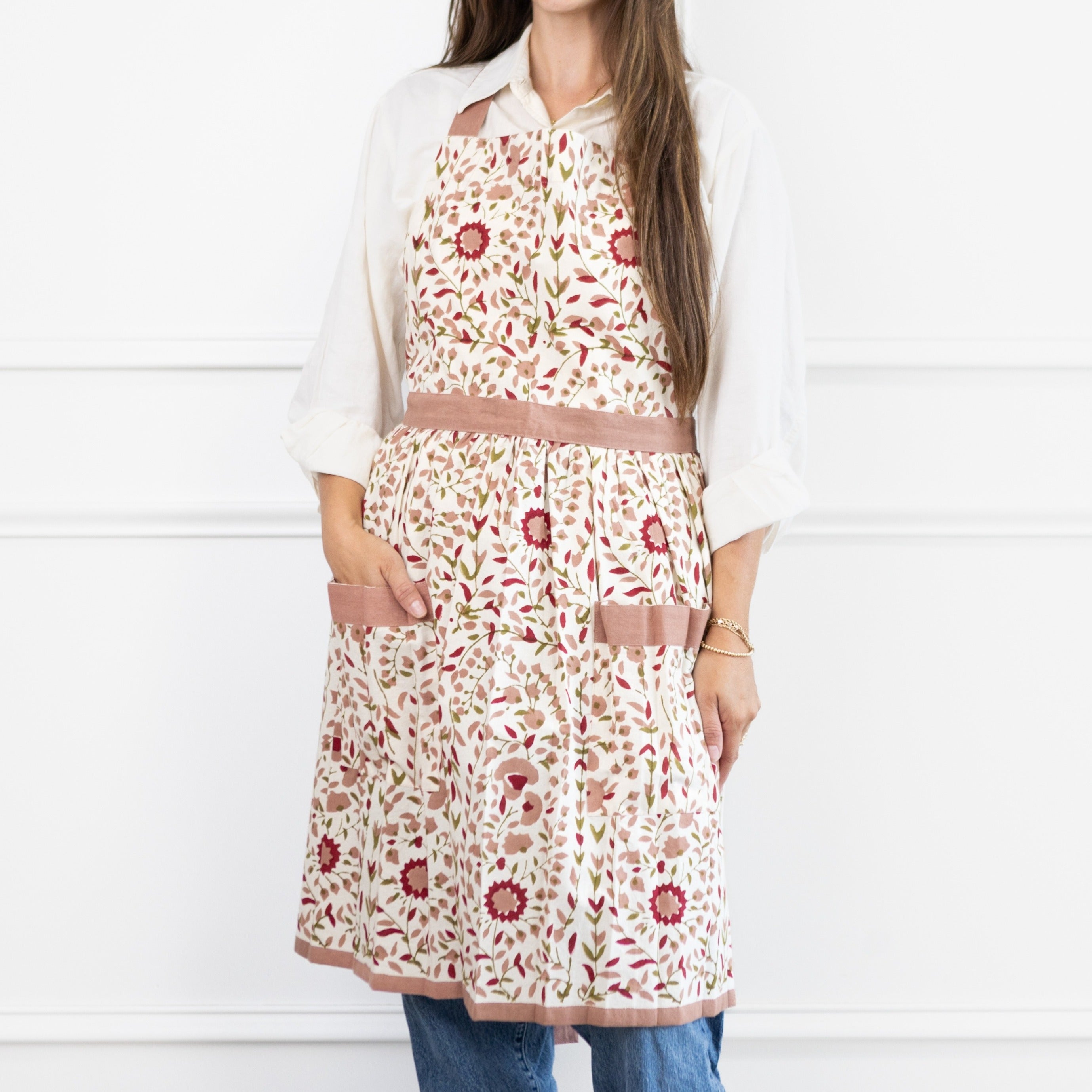 Person wearing a floral apron on a white background
