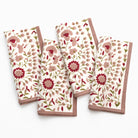Set of four floral-patterned napkins on a white background