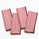 Four pink and red striped napkins on a white background