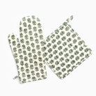 Set of green leaf-patterned pot holder and oven mitt on a white background