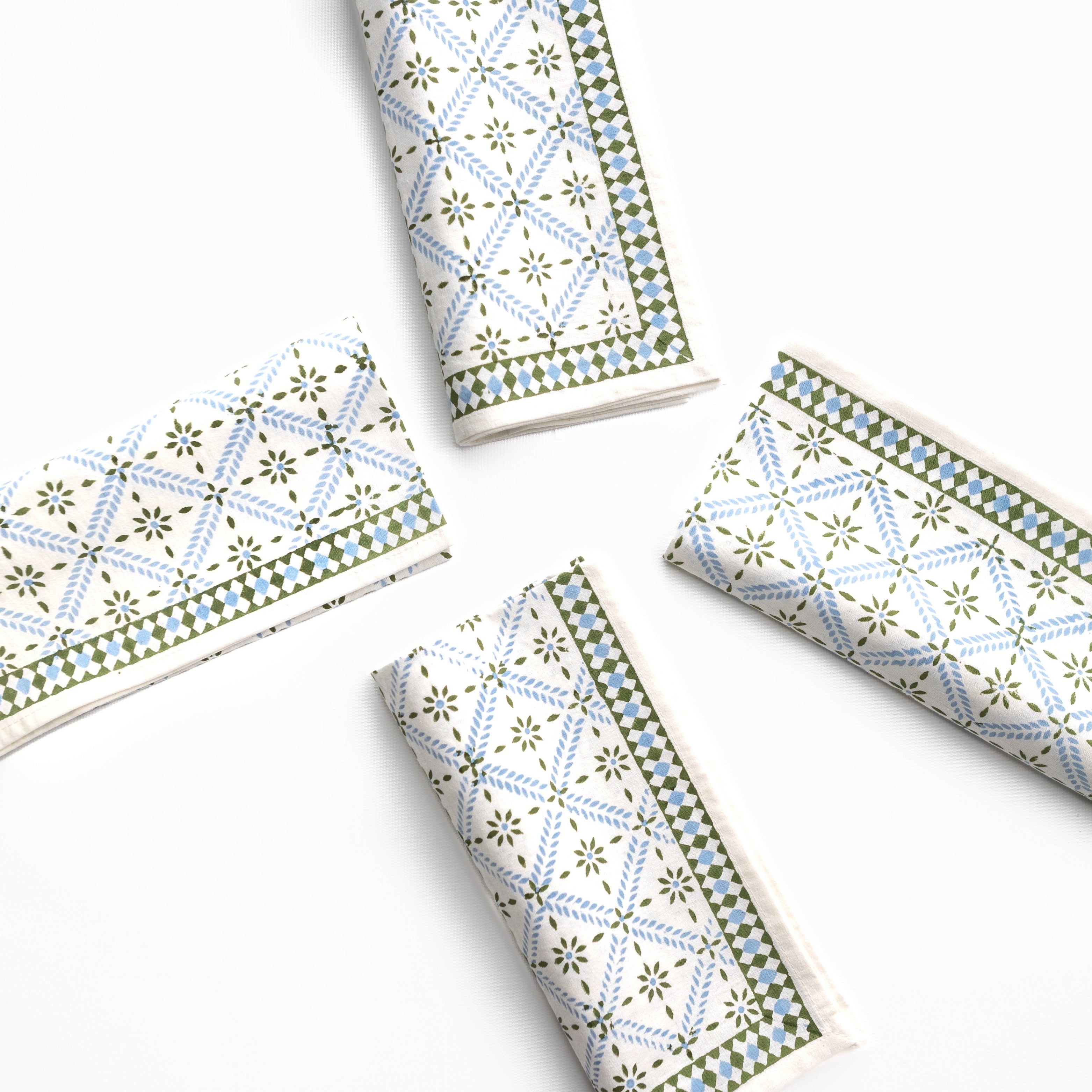 Four folded paper napkins with geometric patterns on a white background