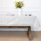 Tablecloth with geometric pattern on a wooden table, white wall background