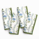 Set of four floral-patterned towels with green borders on a white background