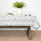 Tablecloth with floral pattern on a wooden table, white wall background