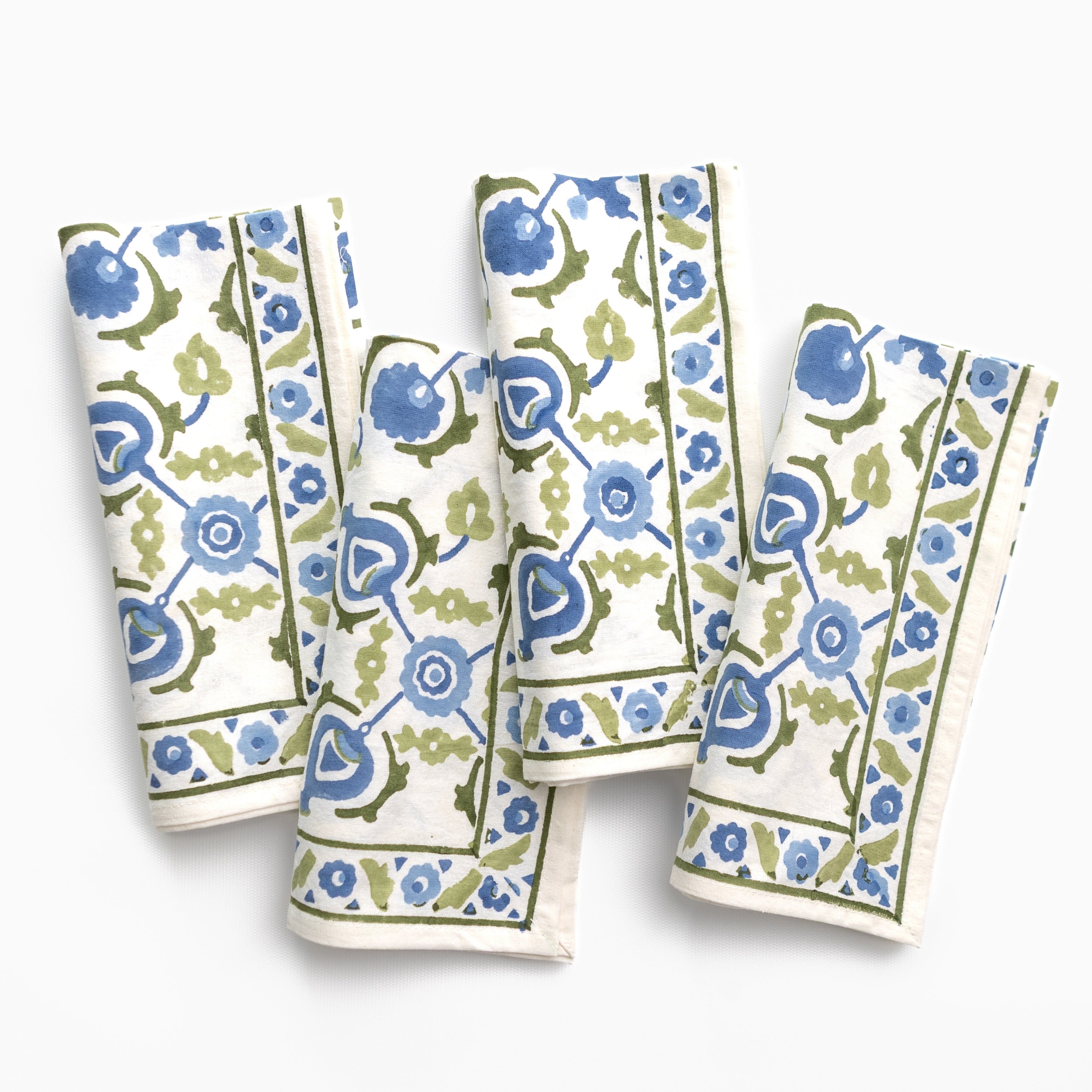 Set of four floral patterned napkins on a white background