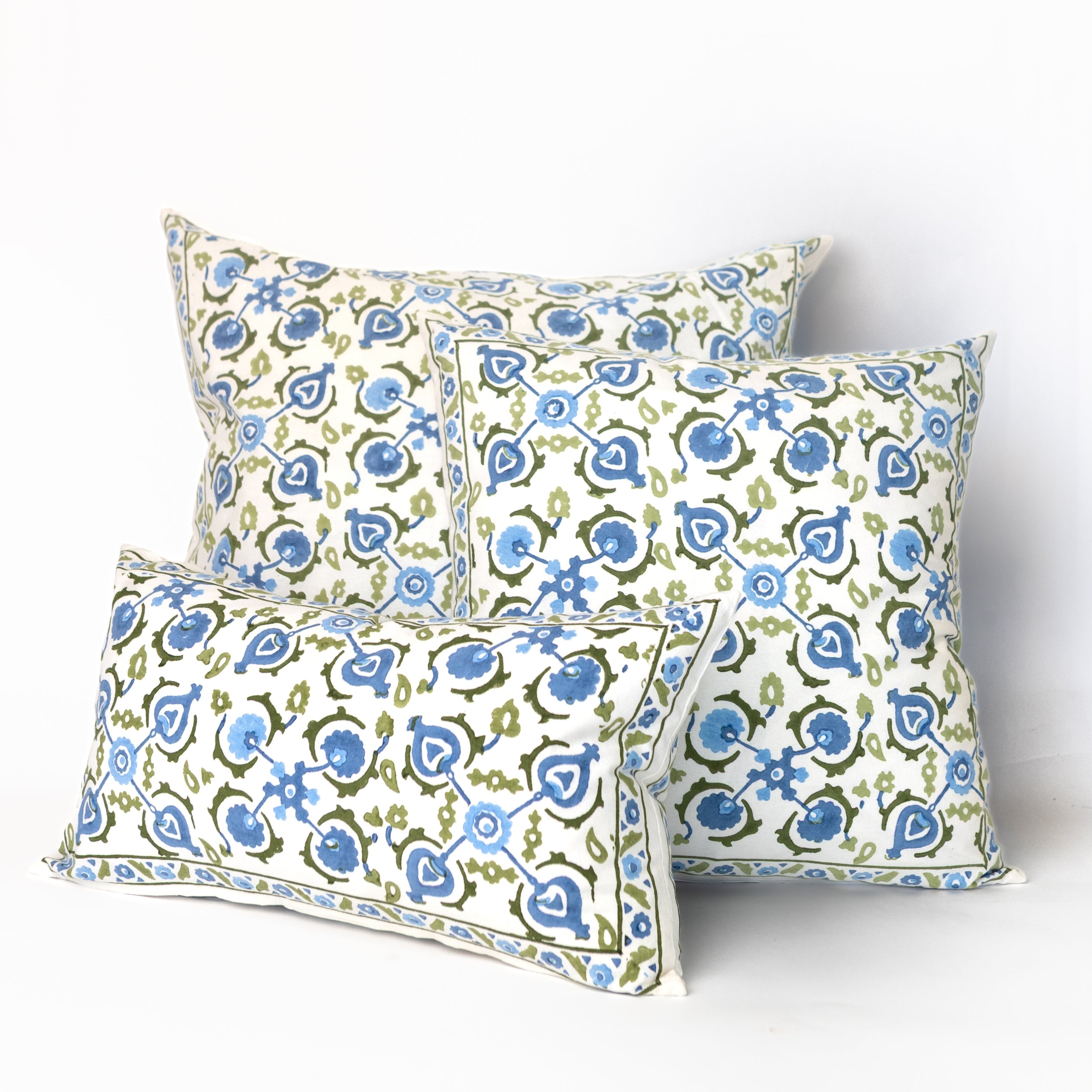 Three decorative pillows with a blue and green pattern on a white background