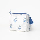 White pouch with blue floral embroidery and tassels on a white background