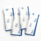 Set of white napkins with blue floral embroidery on a white background