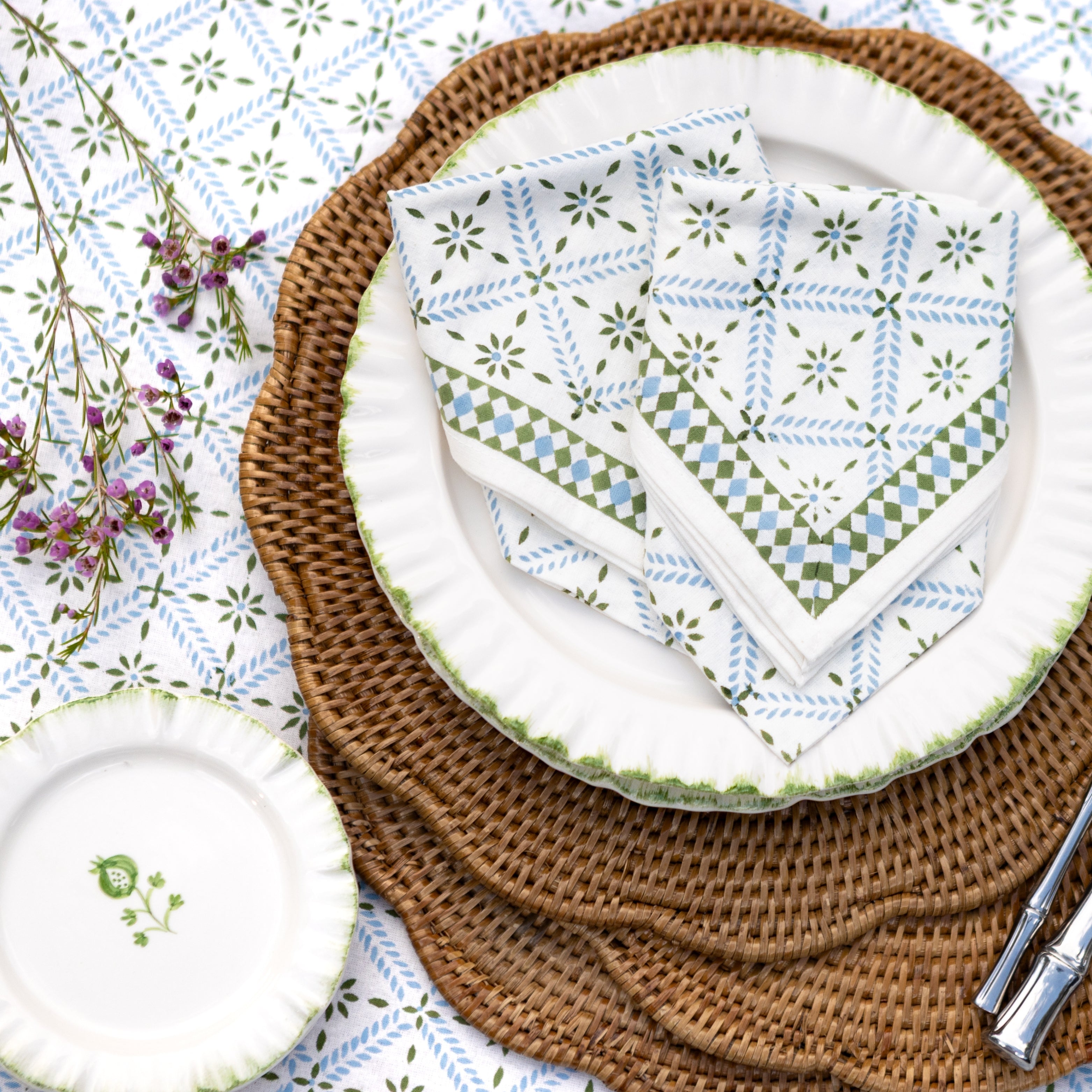 Plated dish with a patterned napkin on a woven placemat, surrounded by decorative elements.