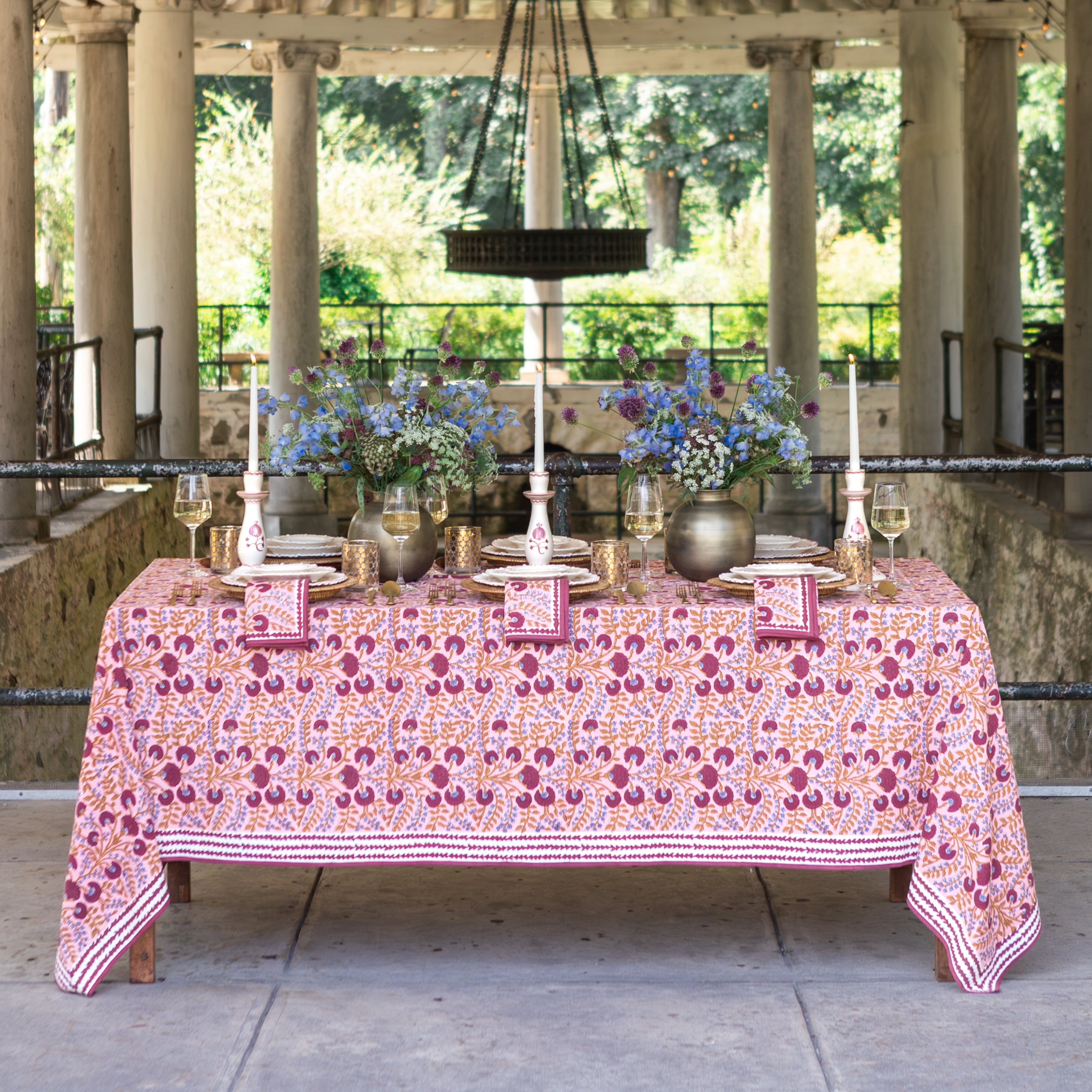 Dining table set with a floral tablecloth in an outdoor setting