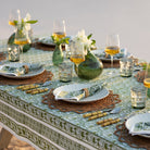 Caroline Green Tablecloth on an outdoor dinner table with wine, flowers, and food.