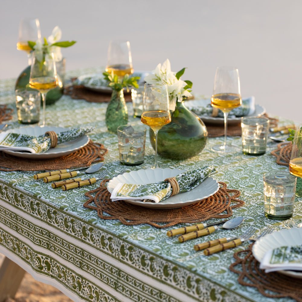 Caroline Green Tablecloth on an outdoor dinner table with wine, flowers, and food. 