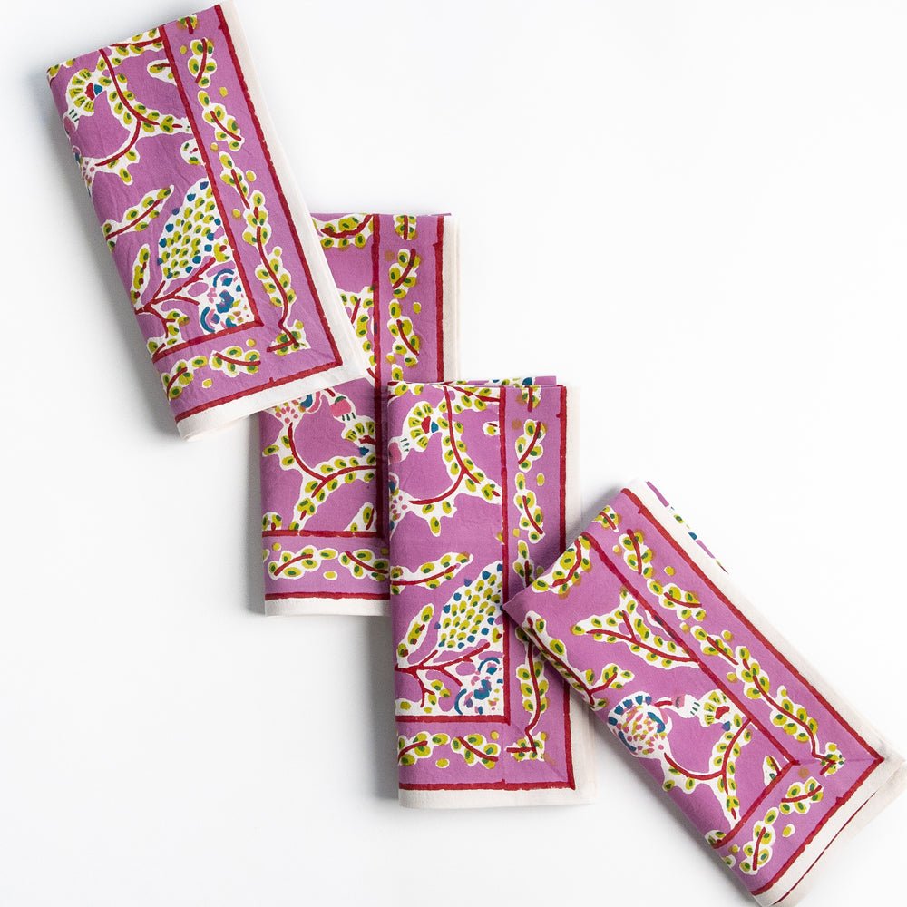 A set of four Climbing Dahlia Lilac Napkins featuring a floral design, set on a white background