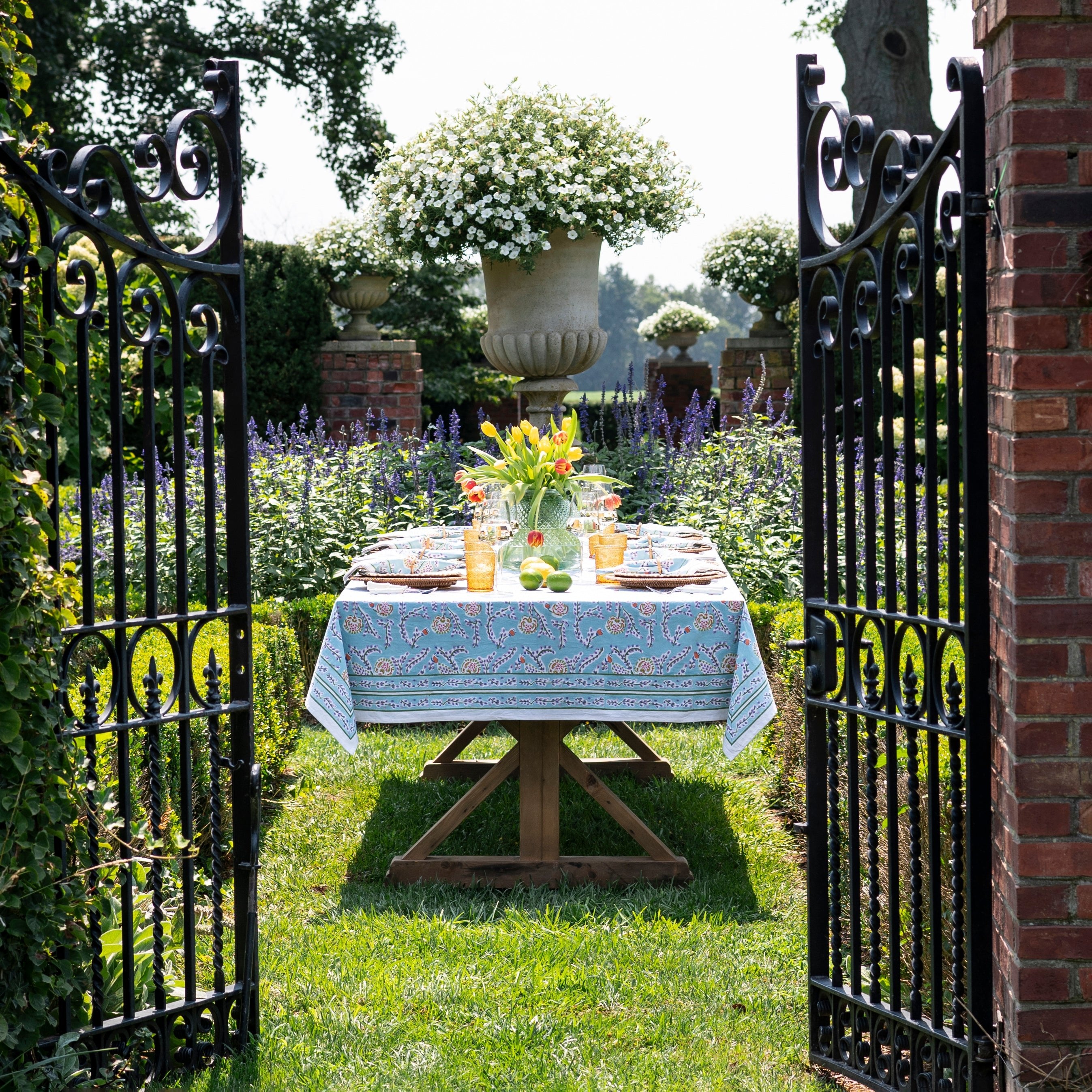 Climbing Dahlia Sky Blue Floral Hand Block Printed Cotton Tablecloth in a garden setting