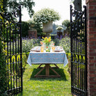 Climbing Dahlia Sky Blue Floral Hand Block Printed Cotton Tablecloth in a garden setting