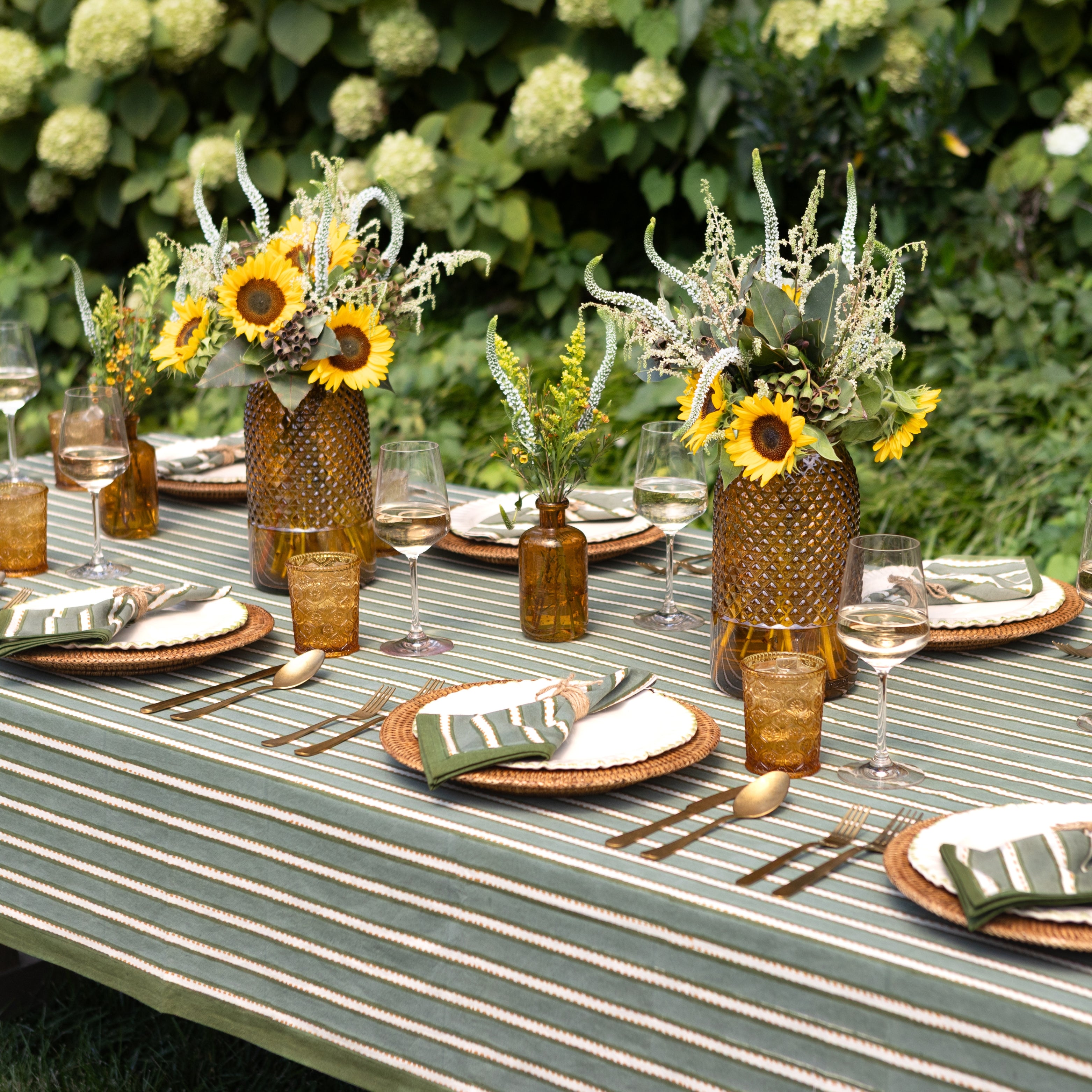 Outdoor table setting with sunflowers and striped tablecloth