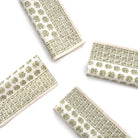 Four folded fabric swatches with green floral patterns on a white background