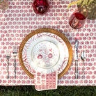 Table setting with floral tablecloth, plates, cutlery, and glasses.